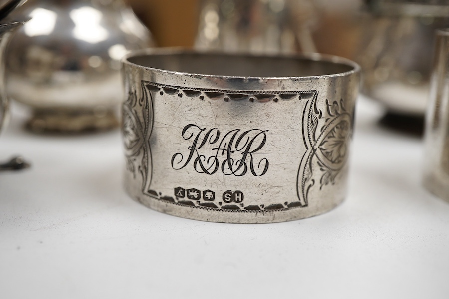 A George V silver three piece condiment set by Walker & Hall, Sheffield, 1921, together withy two other silver condiments, three assorted silver condiment spoons and four assorted silver napkin rings.